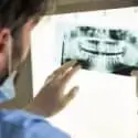 male dentist examines dental x-rays